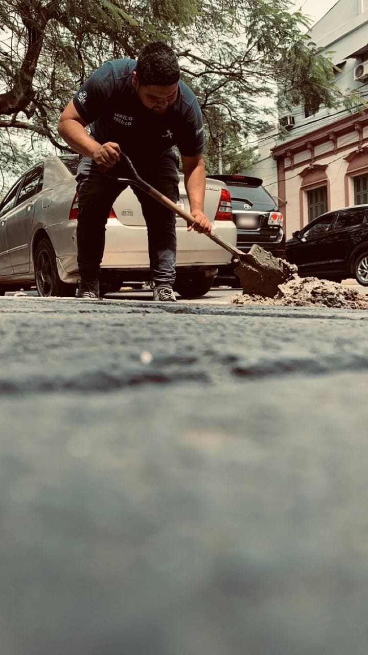 Técnico de JP Multiservice trabajando con pala en una excavación en la calle