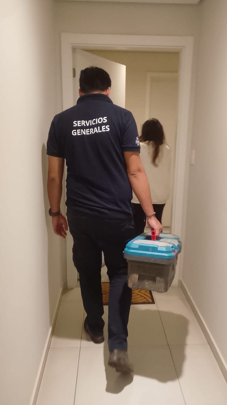 Técnico entrando a un departamento con su caja de herramientas